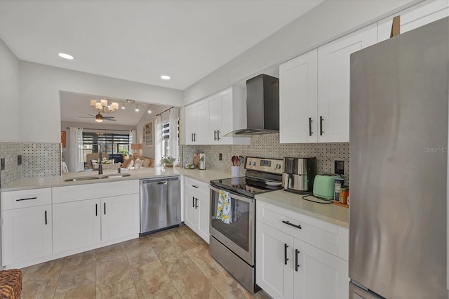 kitchen featuring white cabinets, sink, stainless steel appliances, and wall chimney range hood