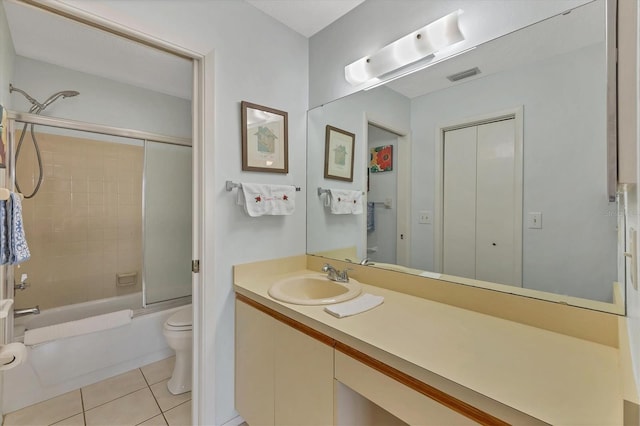 full bathroom with tile patterned floors, vanity, enclosed tub / shower combo, and toilet