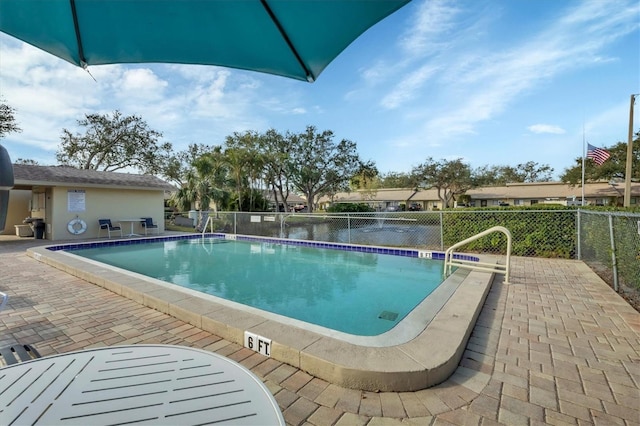 view of swimming pool with a patio area and a water view