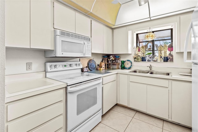 kitchen with white cabinetry, white appliances, sink, and light tile patterned floors