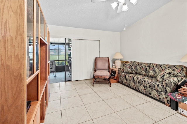 living room with ceiling fan and a textured ceiling