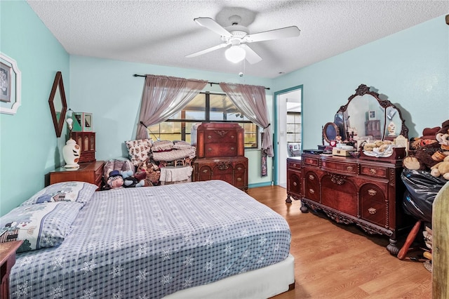 bedroom featuring ceiling fan, light wood-type flooring, and a textured ceiling