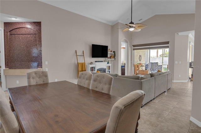 tiled dining room with ceiling fan, vaulted ceiling, and ornamental molding