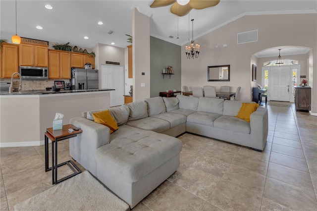 living room with ceiling fan with notable chandelier, vaulted ceiling, and ornamental molding