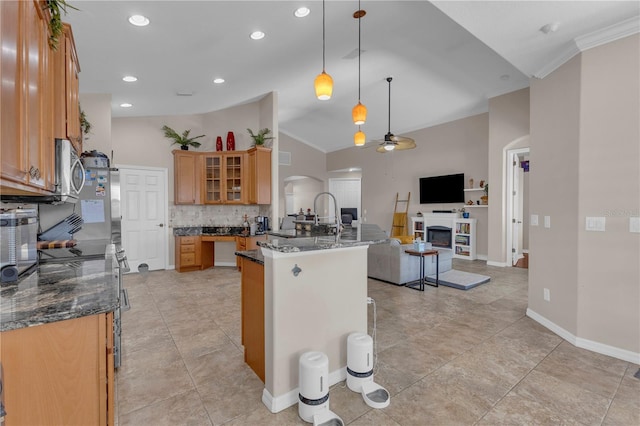 kitchen with crown molding, hanging light fixtures, dark stone counters, and vaulted ceiling