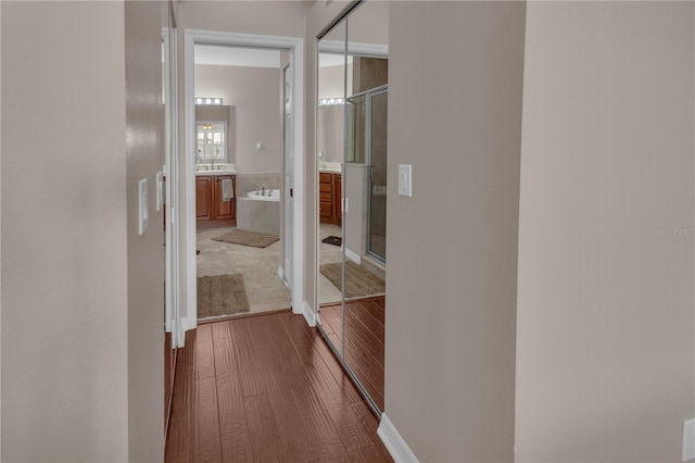 hall with hardwood / wood-style flooring and sink