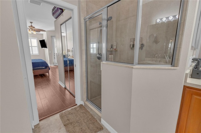 bathroom featuring tile patterned flooring, ceiling fan, and an enclosed shower