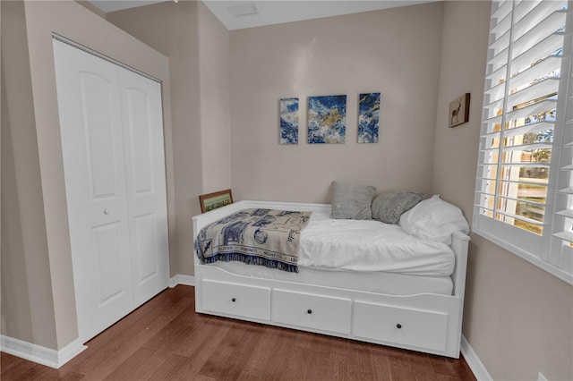 bedroom with hardwood / wood-style floors and a closet