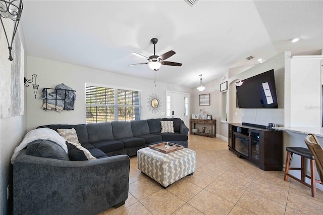 living room with ceiling fan, lofted ceiling, and light tile patterned floors