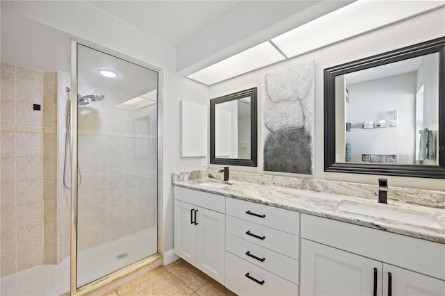 bathroom featuring tile patterned floors, a shower with door, and vanity