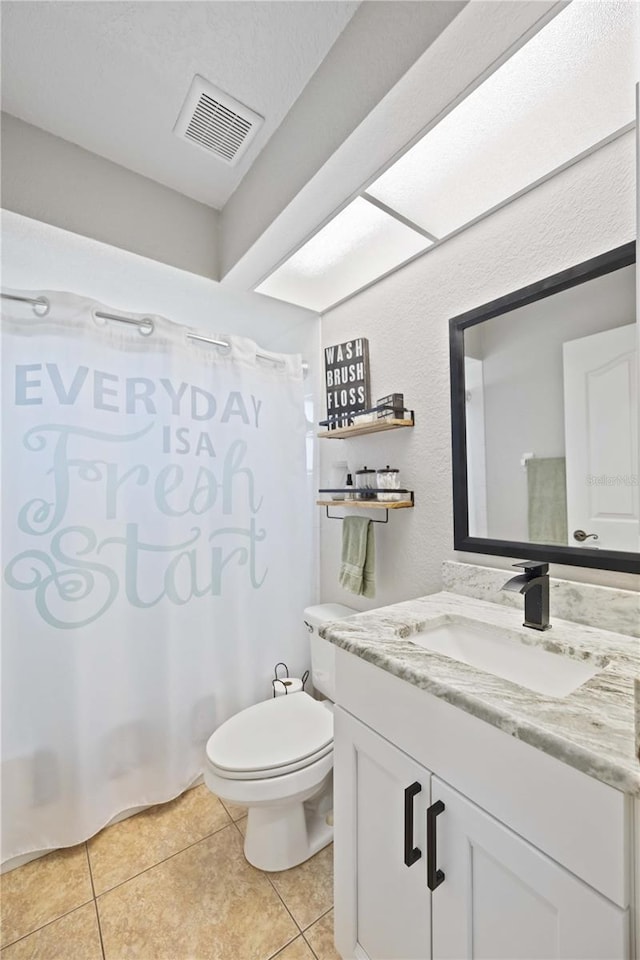 full bathroom featuring tile patterned flooring, vanity, toilet, and shower / bath combo with shower curtain