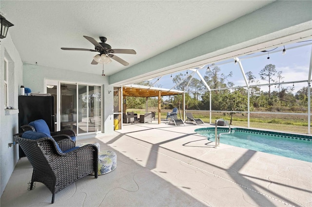 view of swimming pool with ceiling fan, a lanai, and a patio