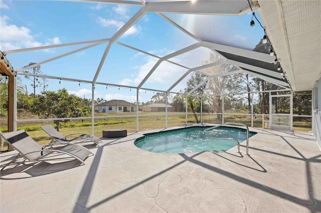 view of swimming pool with glass enclosure and a patio area