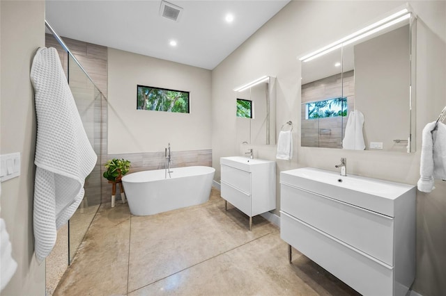 bathroom featuring vanity, concrete flooring, tile walls, and shower with separate bathtub