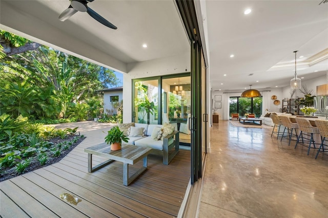 wooden deck with exterior bar, an outdoor living space, and ceiling fan