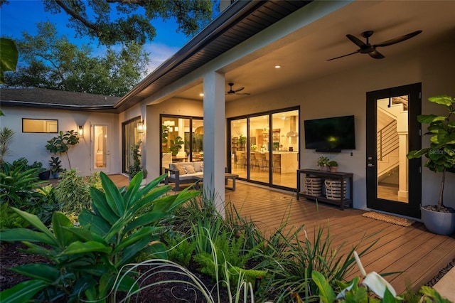 doorway to property with a deck and ceiling fan