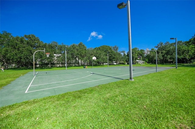 view of basketball court with a yard