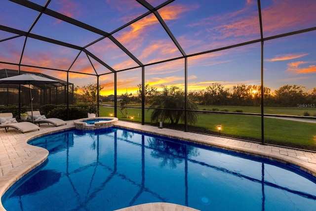 pool at dusk with a lawn, glass enclosure, an in ground hot tub, and a patio