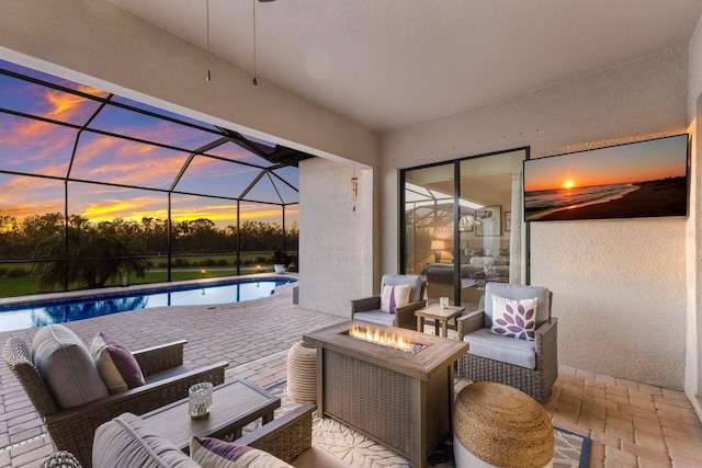 view of patio / terrace with glass enclosure and an outdoor living space with a fire pit