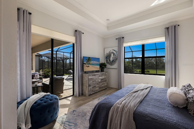 bedroom featuring light wood-type flooring, access to outside, a raised ceiling, and ornamental molding