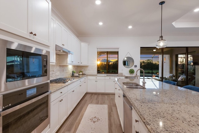 kitchen with white cabinets, appliances with stainless steel finishes, pendant lighting, and sink