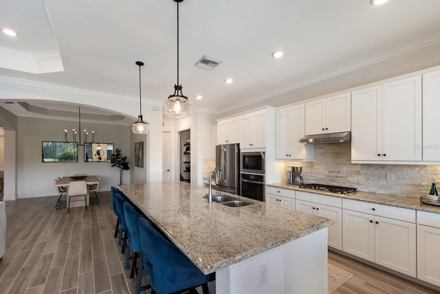 kitchen featuring white cabinets, a kitchen island with sink, and appliances with stainless steel finishes