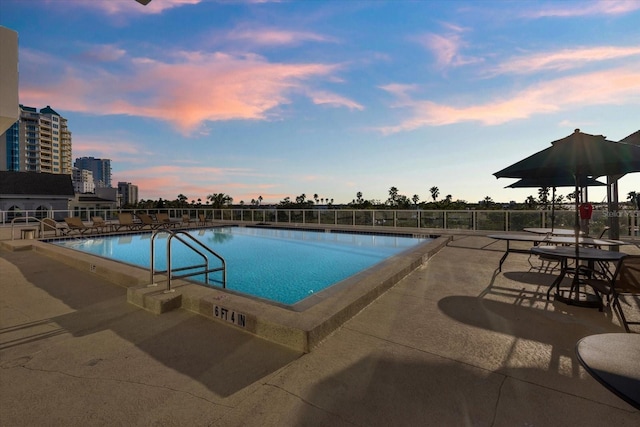 pool at dusk with a patio