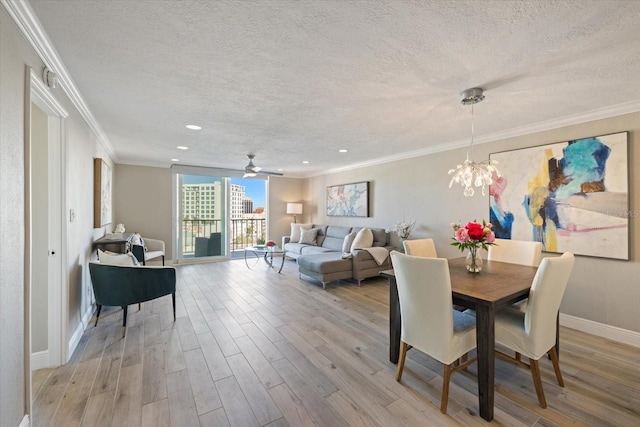 dining room featuring light hardwood / wood-style floors, crown molding, and a textured ceiling