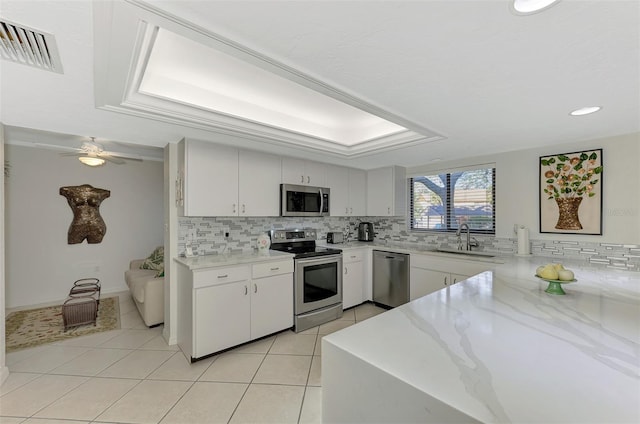 kitchen with white cabinets, light tile patterned floors, sink, and appliances with stainless steel finishes