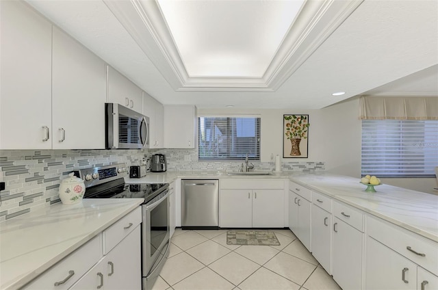 kitchen with white cabinets, ornamental molding, sink, and appliances with stainless steel finishes