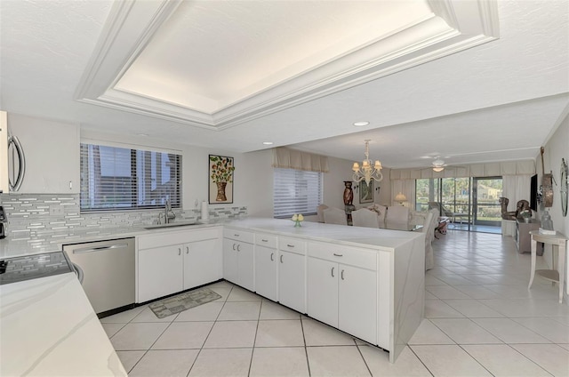 kitchen with dishwasher, sink, kitchen peninsula, decorative backsplash, and white cabinetry