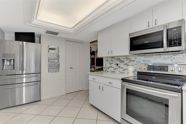 kitchen with white cabinets, decorative backsplash, light tile patterned floors, and appliances with stainless steel finishes