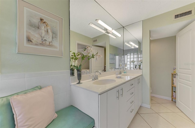 bathroom with tile patterned flooring, vanity, and tile walls