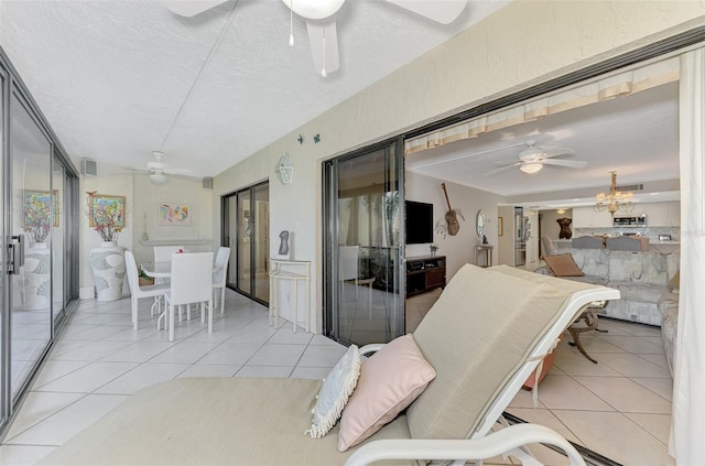 sunroom / solarium featuring ceiling fan with notable chandelier