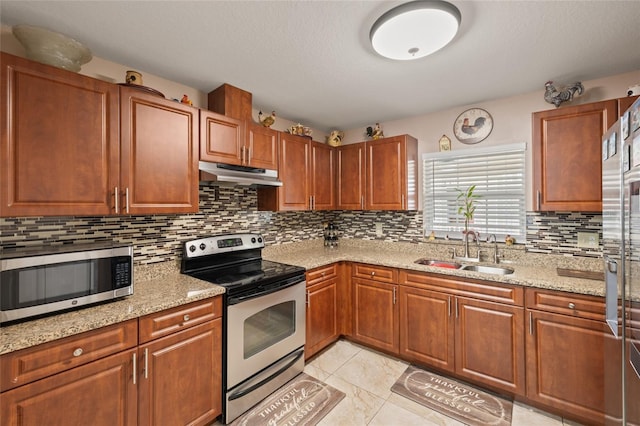 kitchen with light stone countertops, decorative backsplash, stainless steel appliances, sink, and light tile patterned floors