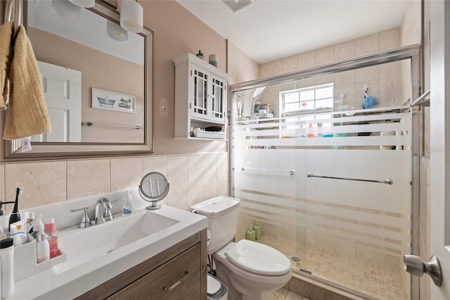 bathroom with decorative backsplash, a shower with door, vanity, and toilet