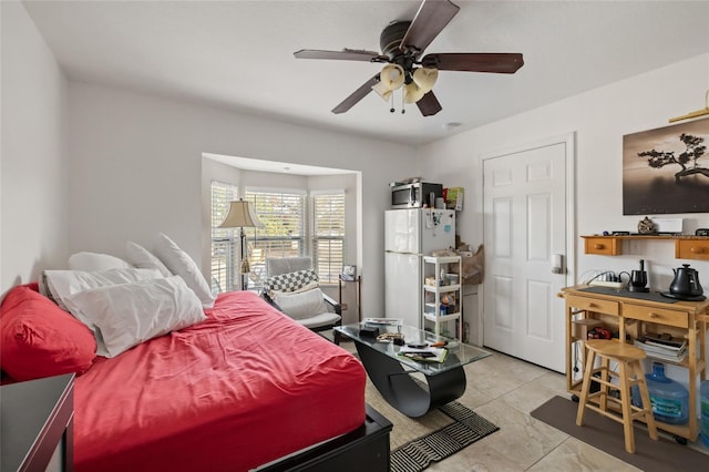 bedroom featuring ceiling fan, white fridge, and light tile patterned flooring