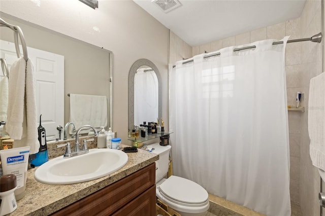 bathroom featuring curtained shower, vanity, and toilet