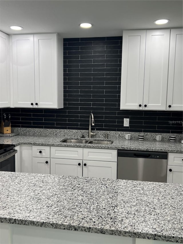 kitchen with tasteful backsplash, white cabinetry, dishwasher, and sink