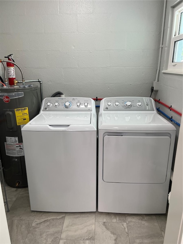 laundry room with washing machine and dryer, water heater, and light tile patterned floors