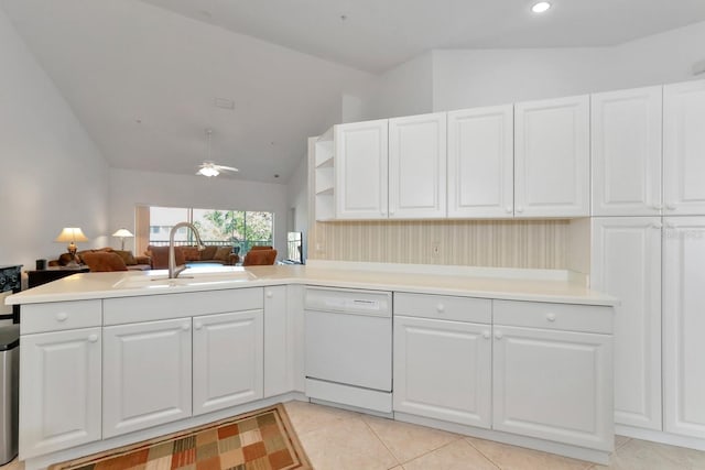 kitchen with kitchen peninsula, white dishwasher, sink, light tile patterned floors, and lofted ceiling