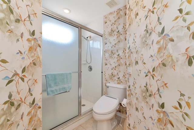 bathroom featuring toilet, a healthy amount of sunlight, tile patterned floors, and a shower with shower door