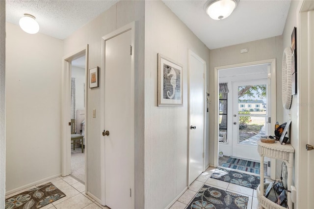 interior space with light tile patterned floors and a textured ceiling