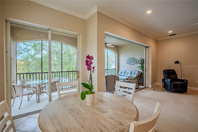 dining room with crown molding, light carpet, and ceiling fan