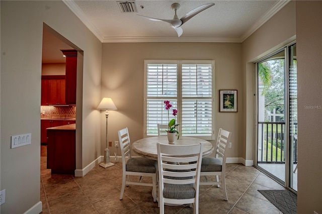 tiled dining area featuring crown molding, a textured ceiling, and ceiling fan