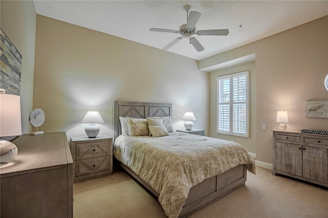 carpeted bedroom with ceiling fan and a textured ceiling