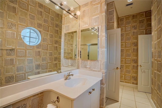 bathroom featuring walk in shower, vanity, and tile patterned flooring