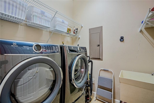 laundry area with independent washer and dryer, electric panel, and sink