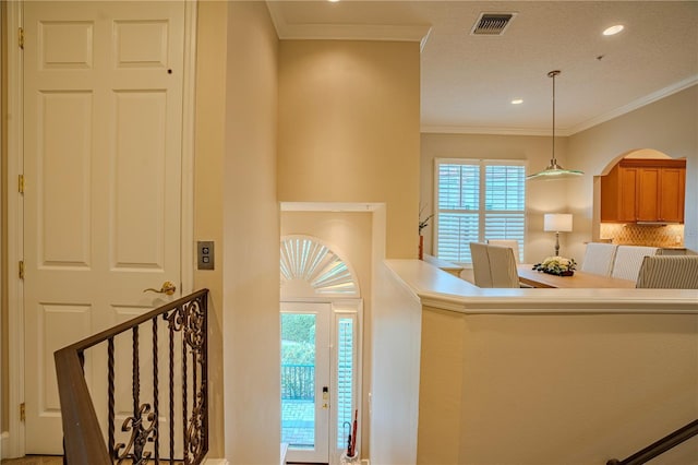 interior space with ornamental molding and plenty of natural light