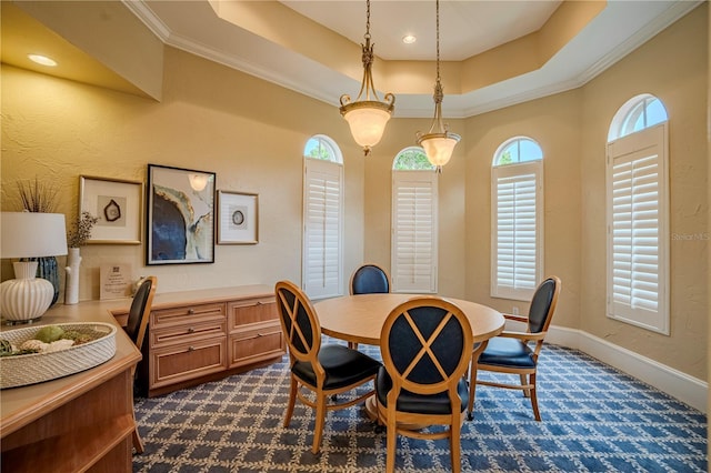 carpeted dining area featuring a tray ceiling and ornamental molding